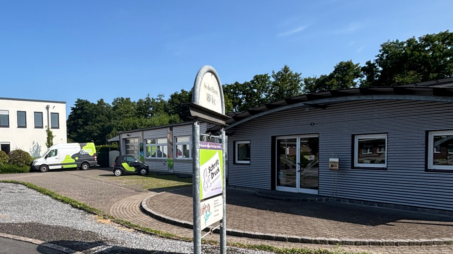 Außenansicht Schrift & Druck in Gronau mit Firmenfahrzeugen